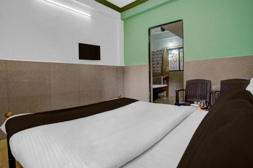 una camera da letto con un letto bianco con uno specchio di Hotel O Calangute Beach Road Formerly Crystal Holiday Homes a Calangute