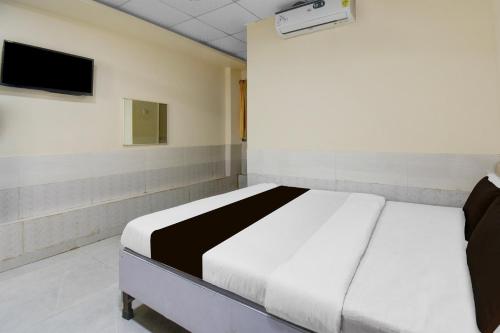 浦那Hotel O Talegaon MIDC Formerly Goodluck Lodge的房间里有一张床的卧室