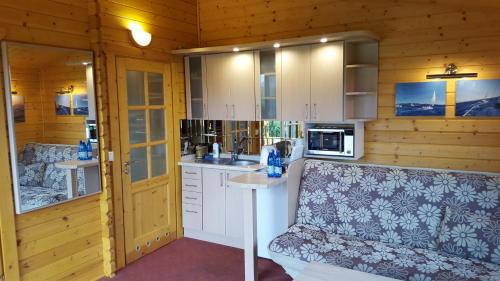 a kitchen with white cabinets and a couch in a room at Aparthotel EuforiaPort in Pisz