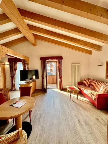 a living room with a couch and a table at Hotel Isolabella Wellness in Fiera di Primiero