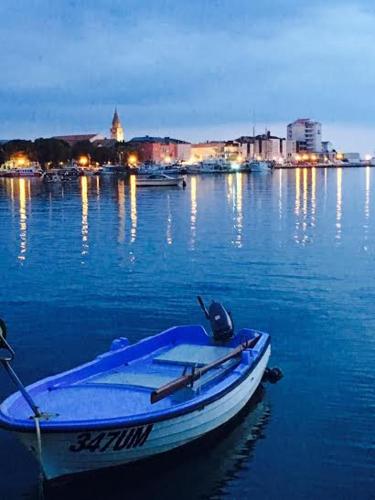 a boat in the water with a city in the background at Apartment Umag Nelly in Umag