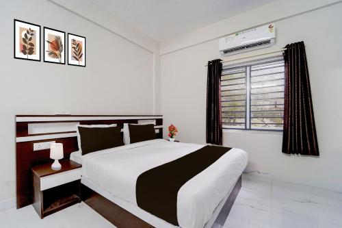 阿鲁法Collection O Aluva Kinfra Hi-Tech Park的卧室里有一张黑白相间的床和一扇窗户