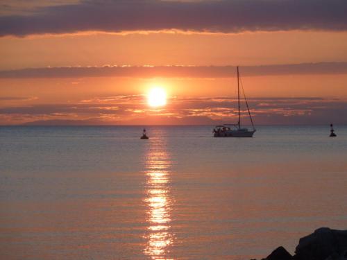 a boat in the water at sunset with the sun setting at Apartment Umag Nelly in Umag