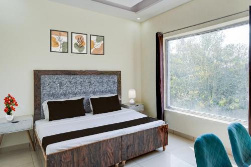a bedroom with a bed and a large window at Hotel O Meerut Central College Formerly Saffron in Meerut