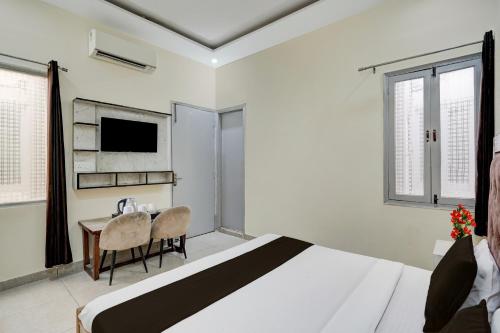 a bedroom with a bed and a table and a television at Hotel O Meerut Central College Formerly Saffron in Meerut