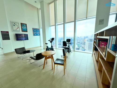 a gym with chairs and a table in a room with windows at Platinum Suites KLCC by Dream'Inn in Kuala Lumpur