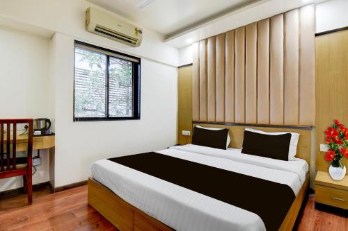 um quarto com uma cama grande com janela em Super Townhouse Viman Nagar Business Stay Formerly Silver Crest em Pune