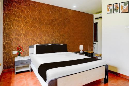 Un dormitorio con una cama y una pared naranja. en Palette by CheckIn Igatpuri Formerly Bodh Valley Resort, en Igatpuri