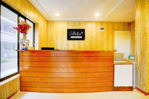 a wooden counter in a restaurant with a sign on the wall at Palette Hotel And Resort Igatpuri Formerly Bodh Valley Resort in Igatpuri