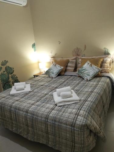 a large bed with two towels on top of it at GLI ELEMENTI Affittacamere Pieve Emanuele - HUMANITAS, IEO, MILANO CENTRO E FORUM ASSAGO in Pieve Emanuele