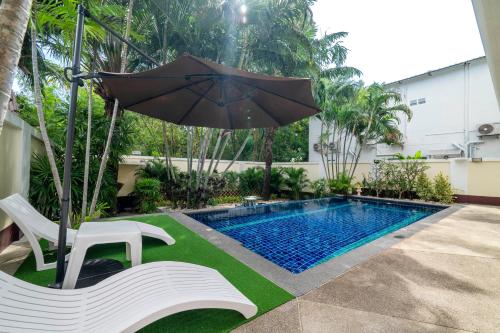 an umbrella and a chair next to a swimming pool at Pattaya Private 4-Bedrooms, 5-Bathrooms Pool Villa in Jomtien Beach