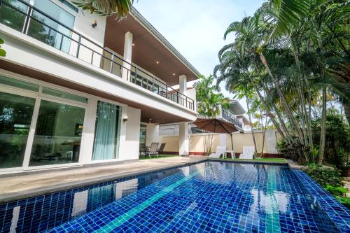 a swimming pool in front of a villa at Pattaya Private 4-Bedrooms, 5-Bathrooms Pool Villa in Jomtien Beach