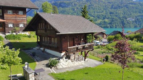 a house in a village with a lake in the background at B & B Brienz in Brienz