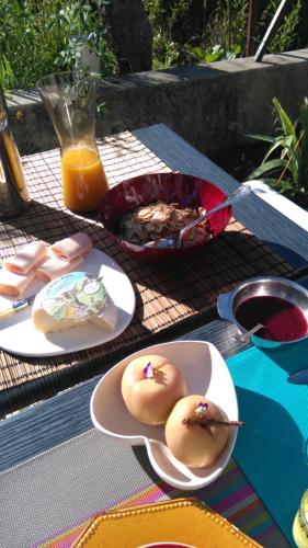 a table with plates of food and a bowl of food at Le Petit Chalande in Autrans