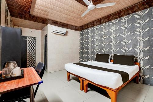 a bedroom with a bed and a desk at Super Hotel O Hindon Airport Ghaziabad in Ghaziabad