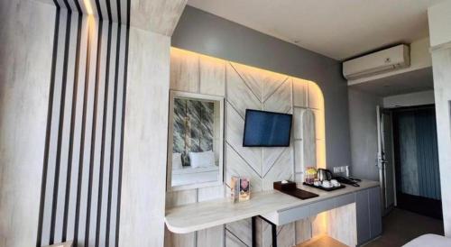 a room with a bed and a desk with a mirror at The Belagri Hotel and Convention in Sorong