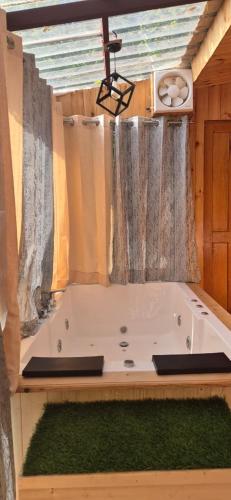 a large bath tub in a room with a window at Skyview Jacuzzi Treehouse Power Backup Tandi in Kulu