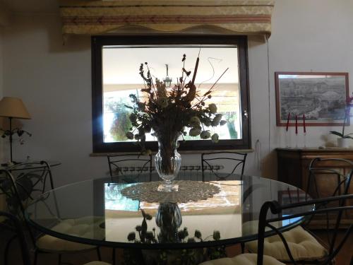 a dining room table with a vase of flowers on it at L'albero Del Pepe in Fiano Romano