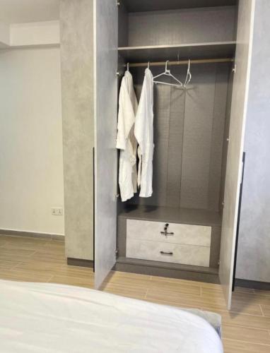 a bedroom with a closet with white towels and a bed at 2 bedrooms apartment in Riverside drive in Nairobi