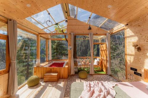 a room with a glass house with a bed in it at Skyview Jacuzzi Treehouse Power Backup Tandi in Kulu