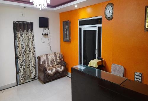 sala de estar con silla y reloj en la pared en POP 84142J Krishnapatnam Grand Inn, en Muttukūru