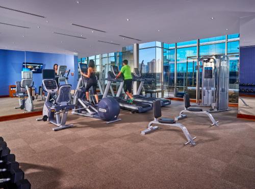 a gym with several people exercising on tread machines at Global Hotel Panama in Panama City