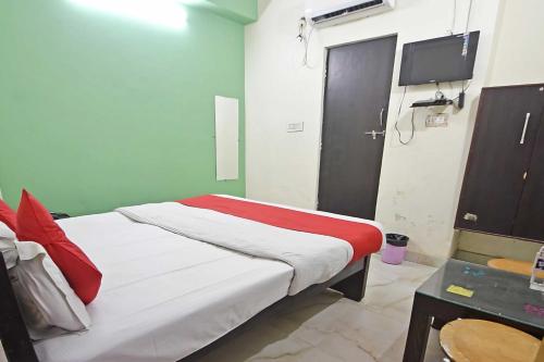 a bedroom with a bed and a tv in it at Hotel O Rajiv Gandhi Bus Stop Bangalore Formerly Maharaja in Jālahalli
