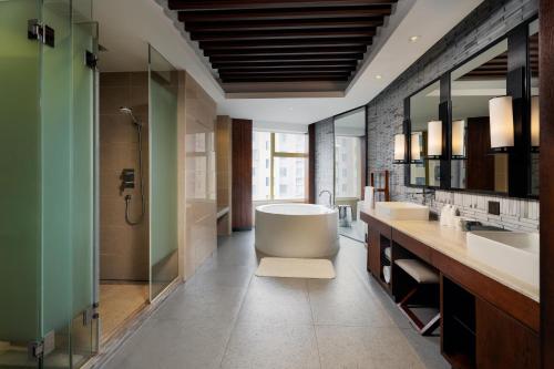 Un baño con dos lavabos y una bañera. en SSAW Boutique Hotel Hangzhou Wildwind, en Hangzhou