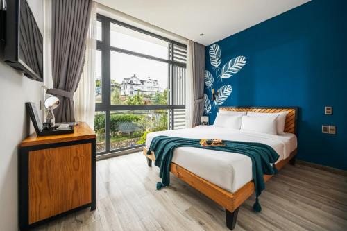 Canary Dalat Hotel في دالات: غرفة نوم بها سرير ونافذة كبيرة