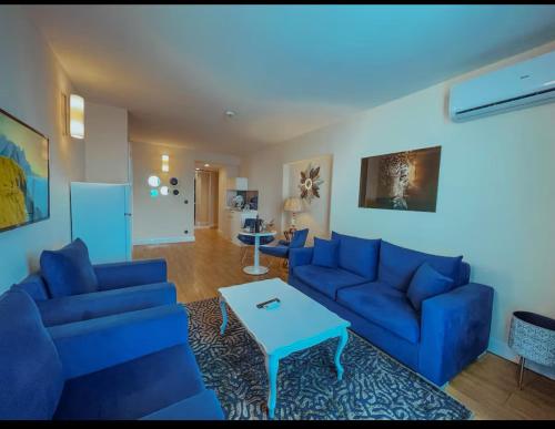 ORBI CITY - Luxury Prestige Hotel في باتومي: غرفة معيشة مع أرائك زرقاء وطاولة