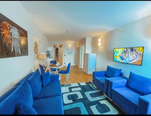 ORBI CITY - Luxury Prestige Hotel في باتومي: غرفة معيشة مع أريكة زرقاء وكراسي زرقاء