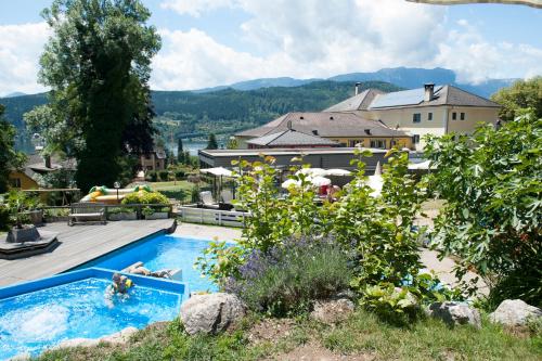 a swimming pool in a yard with a house at Familienhotel Post in Millstatt
