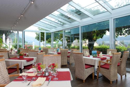 a restaurant with tables and chairs and windows at Familienhotel Post in Millstatt