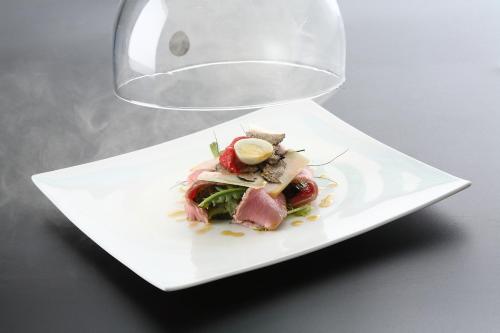 a white plate with food on a table at Parizzi Suites & Restaurant in Parma