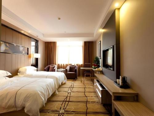 ein Hotelzimmer mit einem großen Bett und einem Flachbildfernseher in der Unterkunft Century Land Hotel Wuyishan in Ch'ung-an-hsien