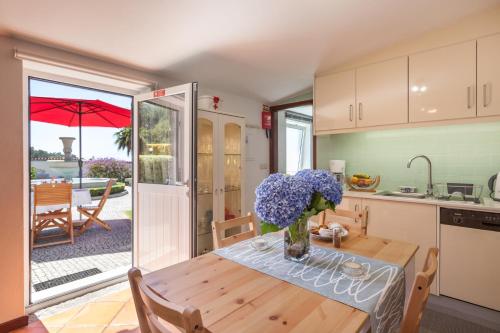 a kitchen with a table with a vase of flowers on it at Casa do Chafariz in Viana do Castelo
