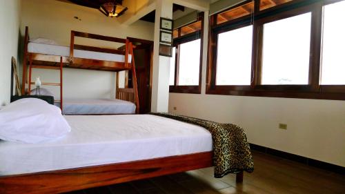 a bedroom with two bunk beds and two windows at Hotel Sotavento in Montañita