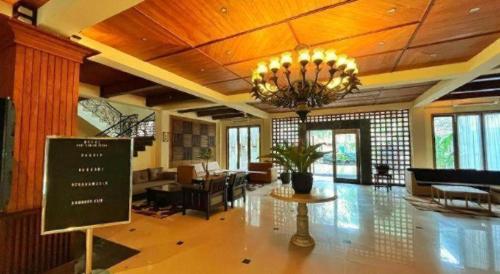un'ampia hall con lampadario pendente e soggiorno di HOTEL SARI KURING INDAH a Cilegon
