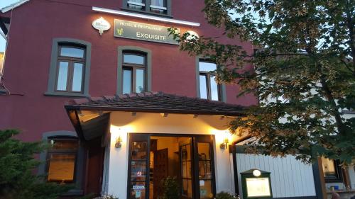 a building with a sign on the front of it at Hotel Exquisite in Bobenheim am Berg