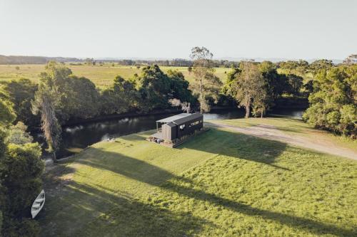 an aerial view of a house in a field next to a river at Riverfront Luxury Stay Tiny House Sauna and Bath in Old Bar