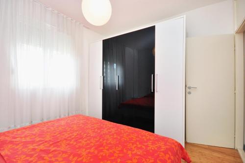 1 dormitorio con cama roja y puerta negra en Apartment Ivan, en Split