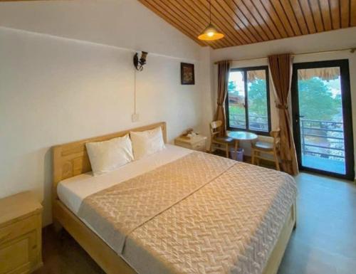 a bedroom with a bed in a room with windows at Catba Oasis Bungalows in Cat Ba