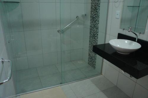 a bathroom with a glass shower with a sink and a toilet at Pousada Mirantes Do Sincorá in Mucugê