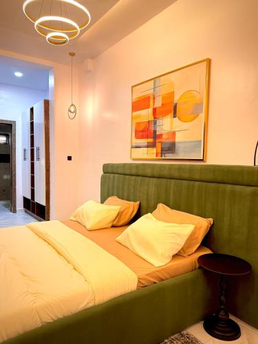 a bed in a bedroom with a painting on the wall at Cozy Apartment in Lekki in Lekki