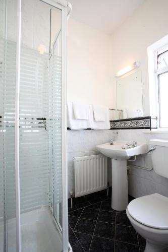 a white bathroom with a sink and a shower at Brooklodge Bed and Breakfast in Westport