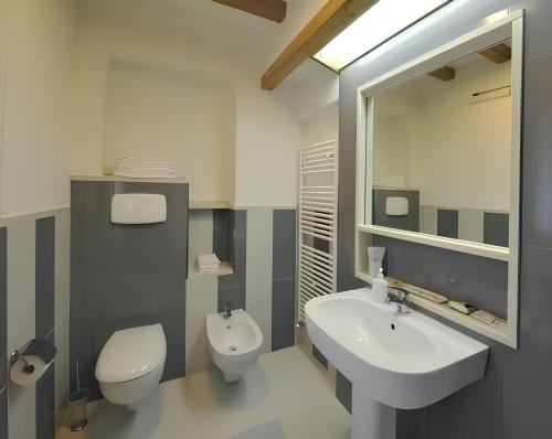 een badkamer met een wastafel, een toilet en een spiegel bij Gustet 5 - Prosecco Hills Holidays in Miane