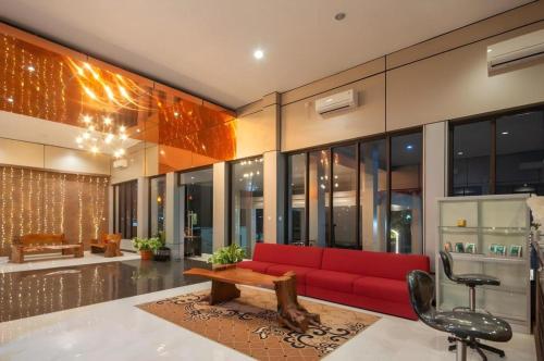 un soggiorno con un divano rosso e un tavolo di Sumbawa Grand Hotel a Sumbawa Besar