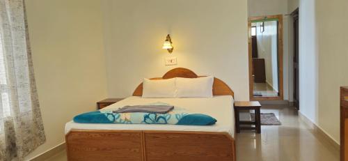 a bedroom with a bed with a wooden headboard at East Home Stay in Dharmsala