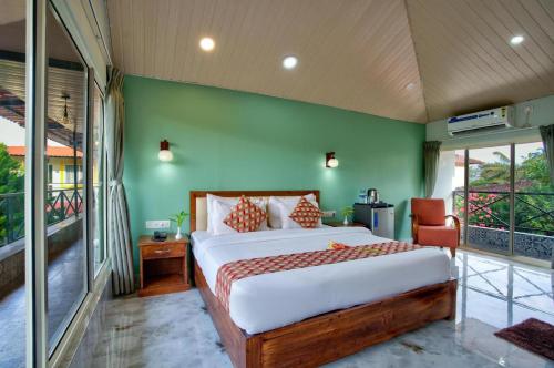 a bedroom with a bed and a green wall at Maya Beach Resort Near Vagator Petrol Pump Anjuna in Vagator