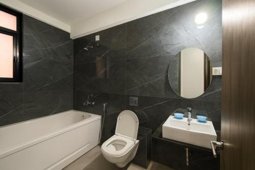 The Vintage Luxury Serviced Apartment في بيون: حمام مع مرحاض ومغسلة وحوض استحمام